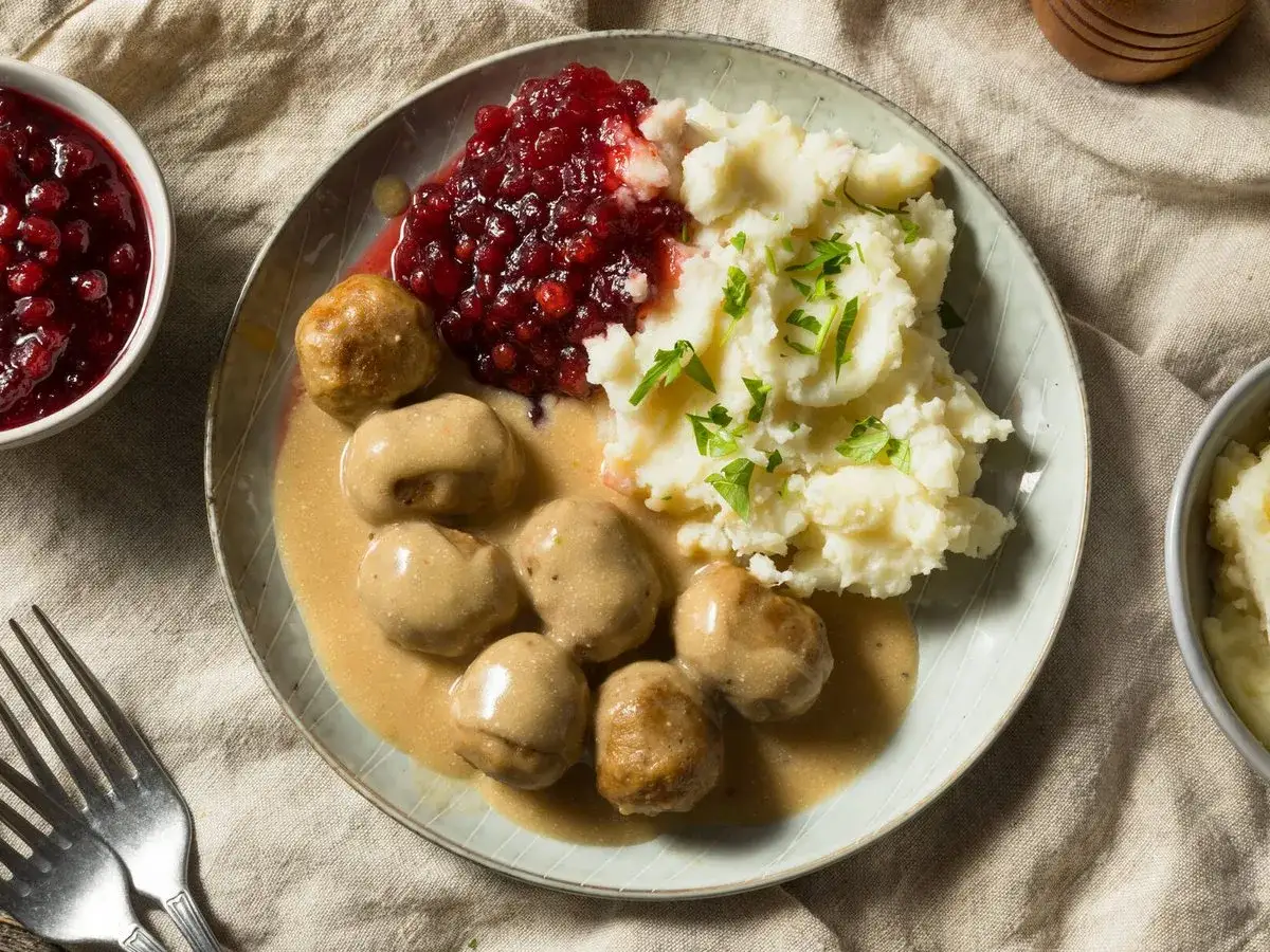 K&ouml;ttbullar med kr&auml;mig brun s&aring;s, potatismos och r&aring;r&ouml;rda lingon. En klassisk svensk r&auml;tt som doftar hemtrevnad.