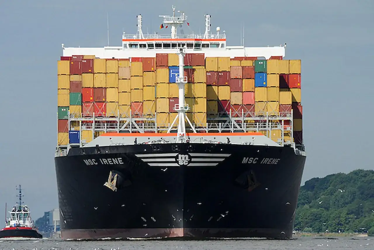 Die MSC Irene, ein riesiges Containerschiff, f&auml;hrt auf dem Wasser. Ein Schlepper begleitet sie.
