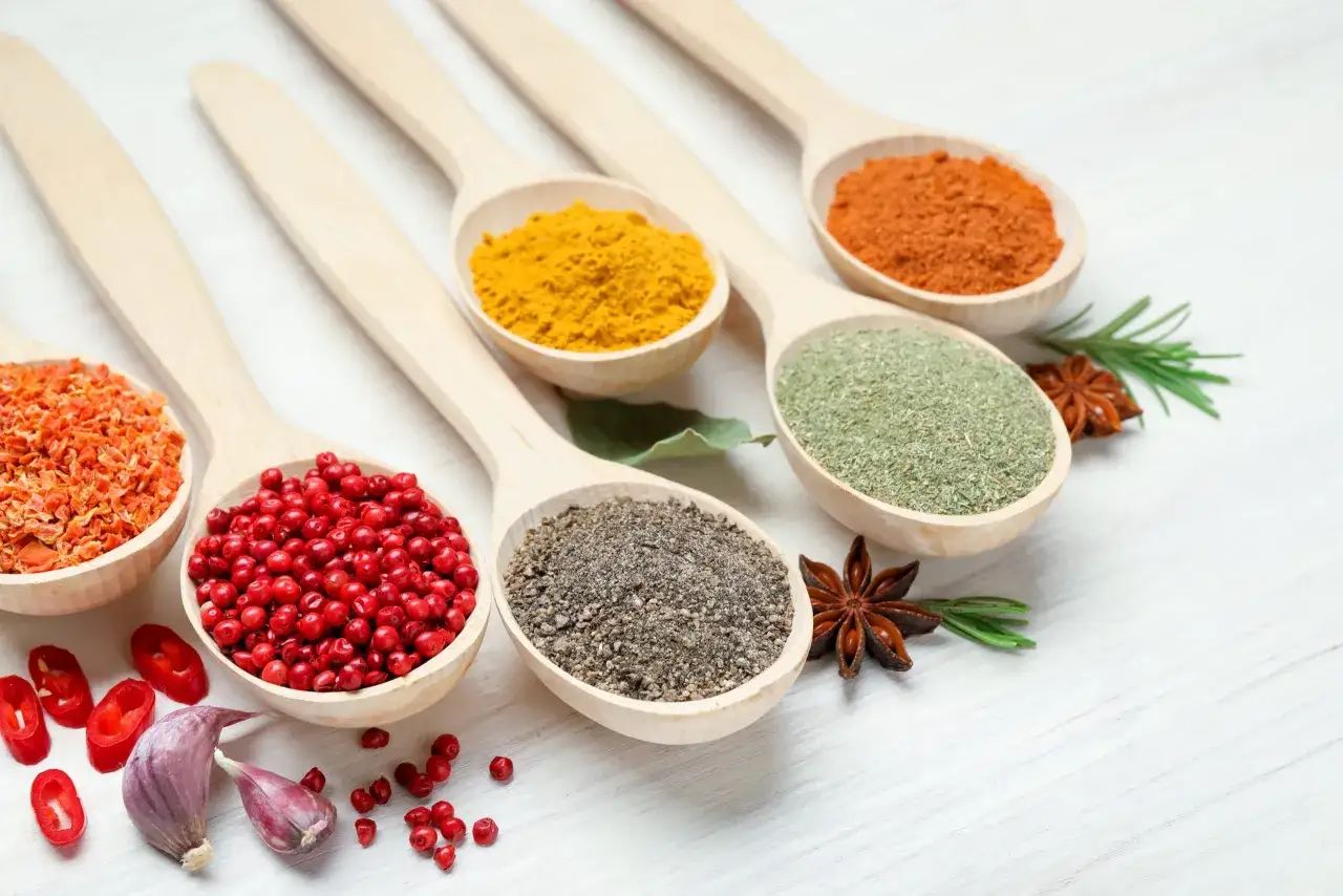 Cuillères en bois remplies d'épices colorées : curcuma, poivre, herbes, piment. Laquelle est l'anti-inflammatoire naturel le plus efficace ?