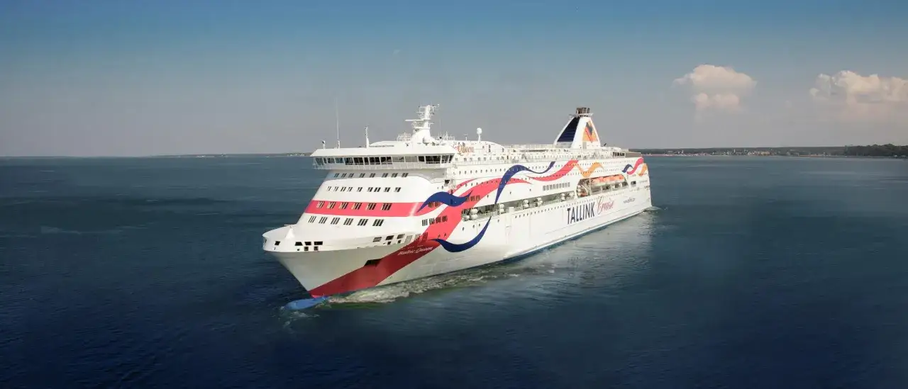 Baltic Queen båt glider fram på det blå havet, med sina färgglada linjer som speglar sig i vattnet.