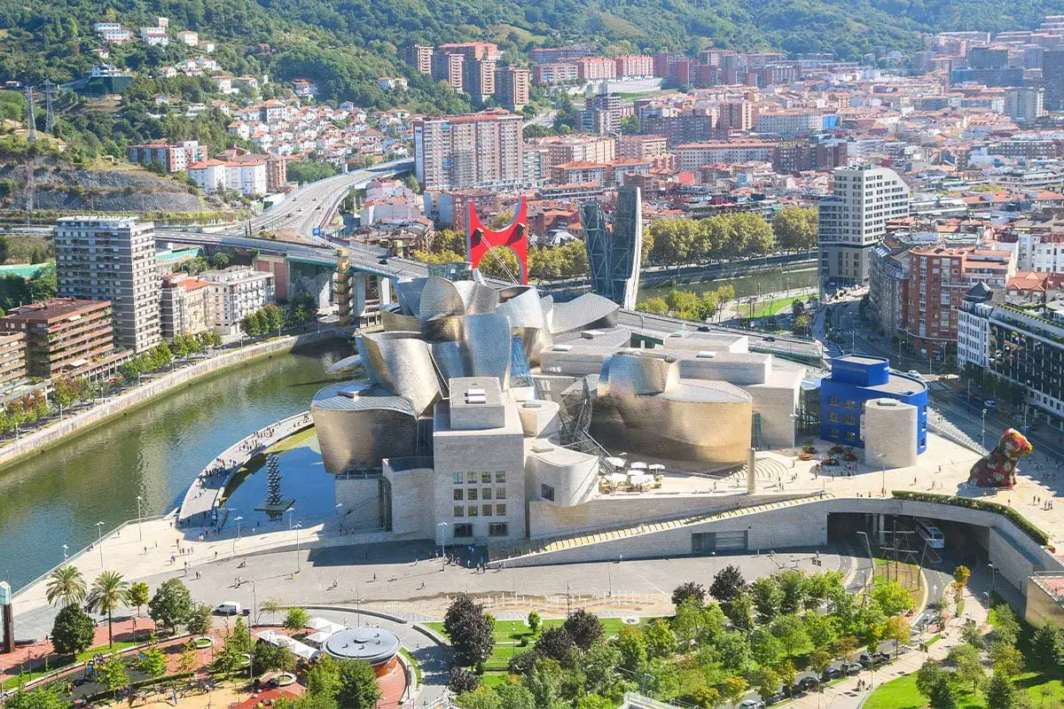 Widok na Muzeum Guggenheima w Bilbao, największym mieście kraju Basków, z rzeką Nervión i otaczającą zabudową.