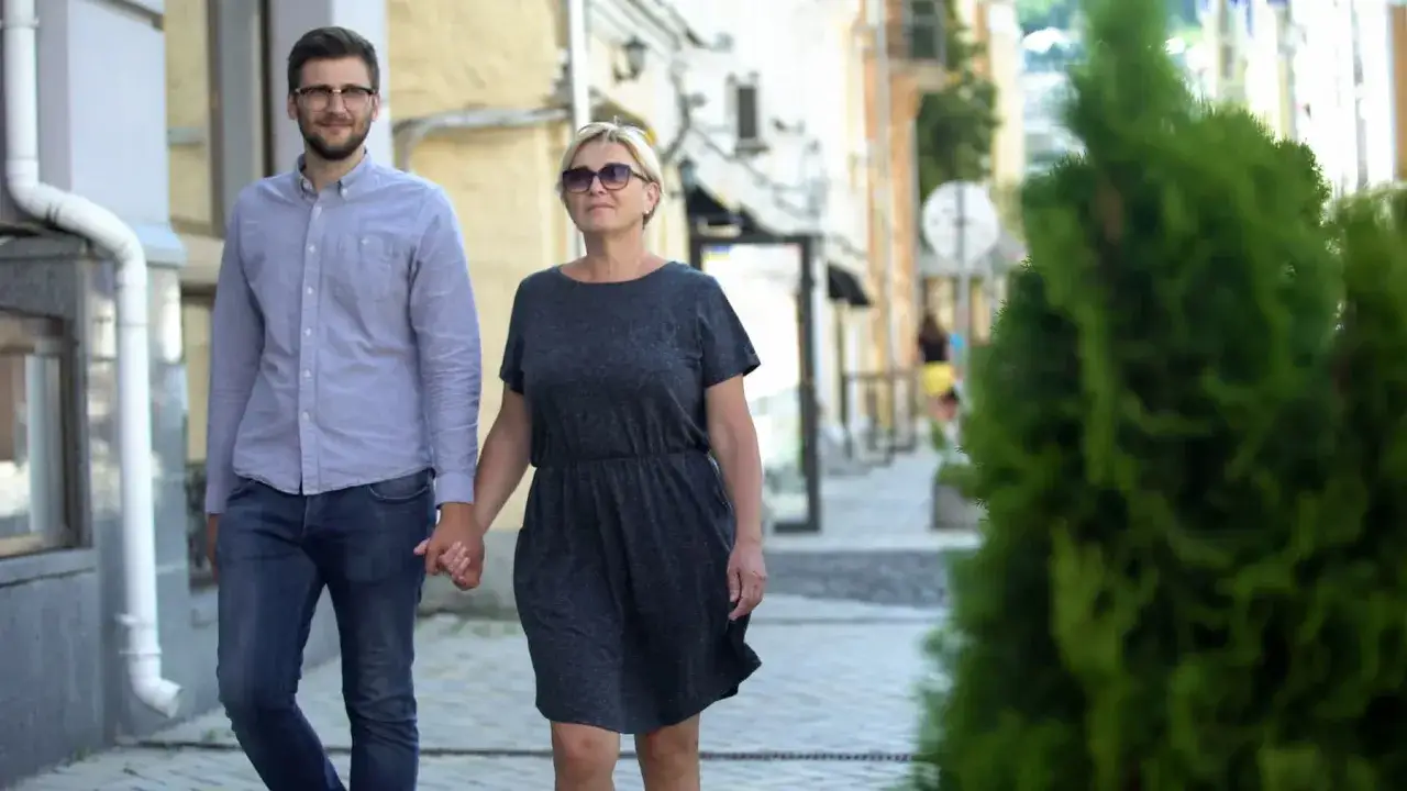 Para w różnym wieku, siedząca na ławce, rozmawiająca