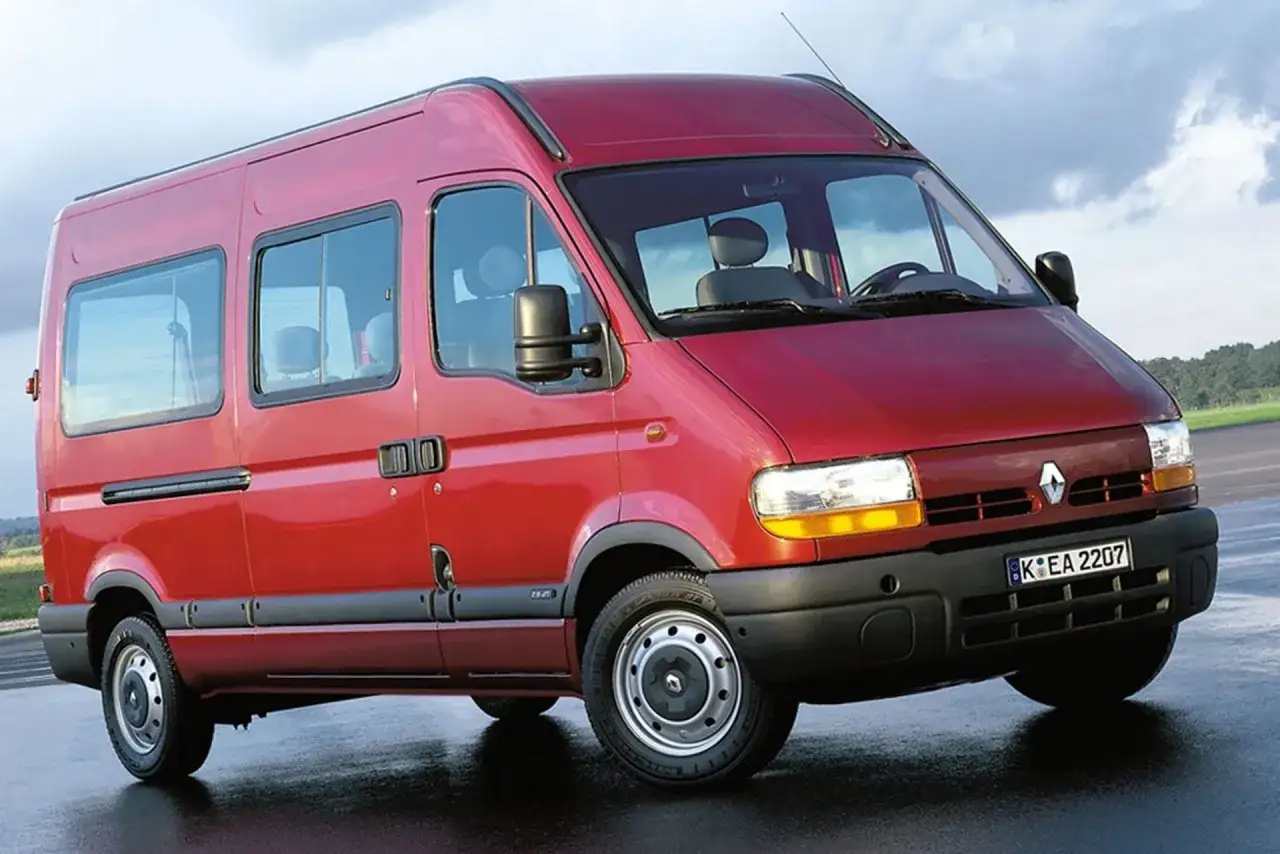 Czerwony Renault Master 2, przestronny bus z przyciemnianymi szybami, gotowy na podróż.
