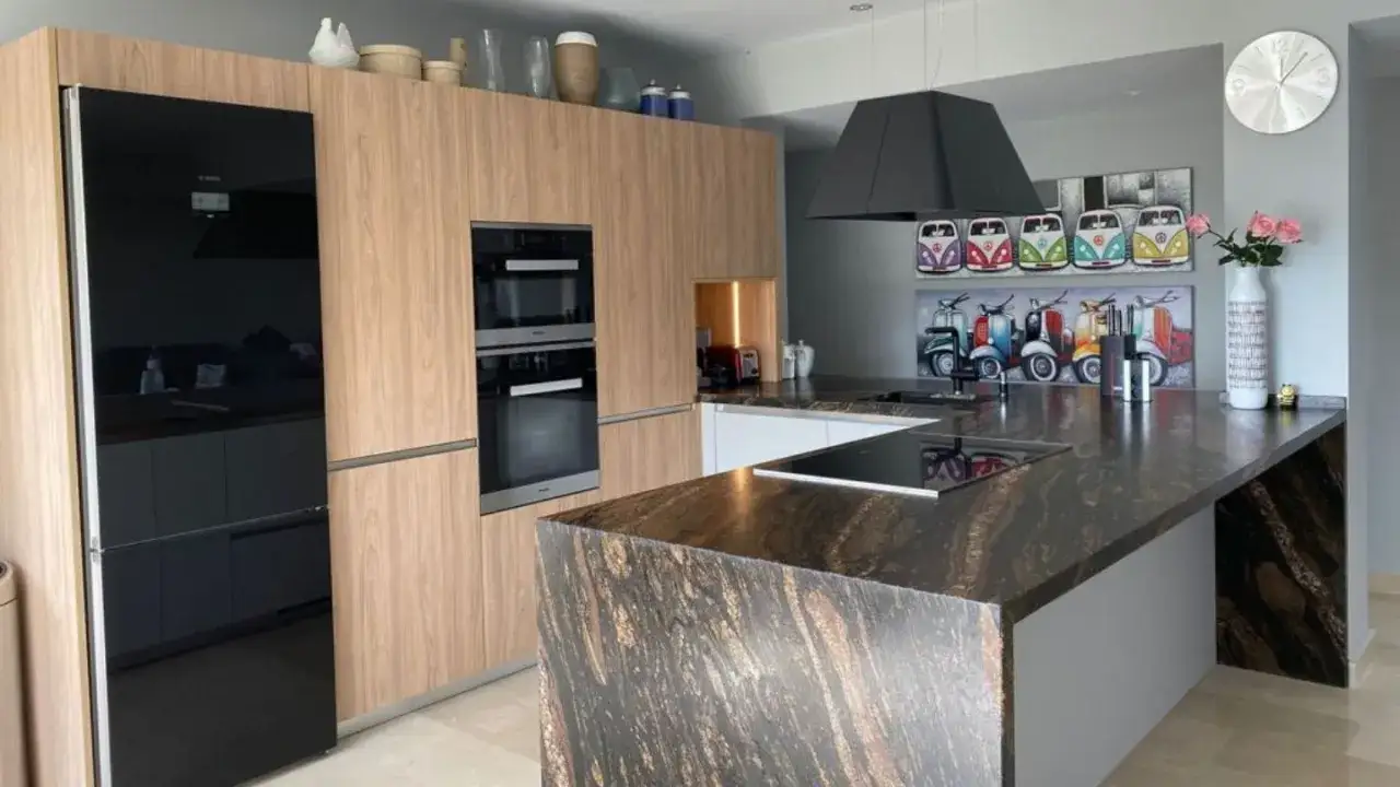 Cocina moderna con electrodomésticos integrados, encimera de granito y arte retro de furgonetas y scooters. ¡Ideas de cocinas únicas!