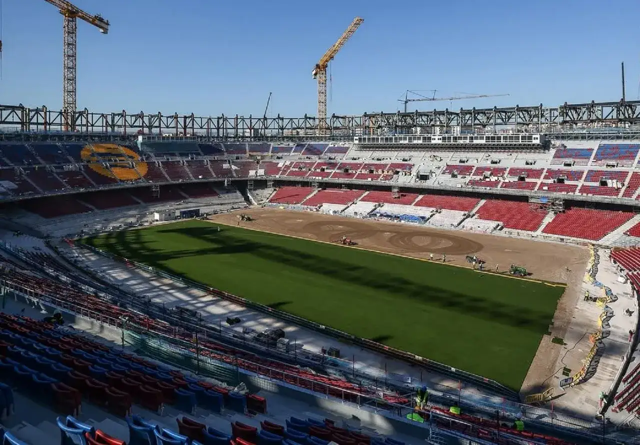 Widok na budowę nowego Camp Nou. Trwa układanie murawy, w tle widać żurawie i konstrukcje stadionu.