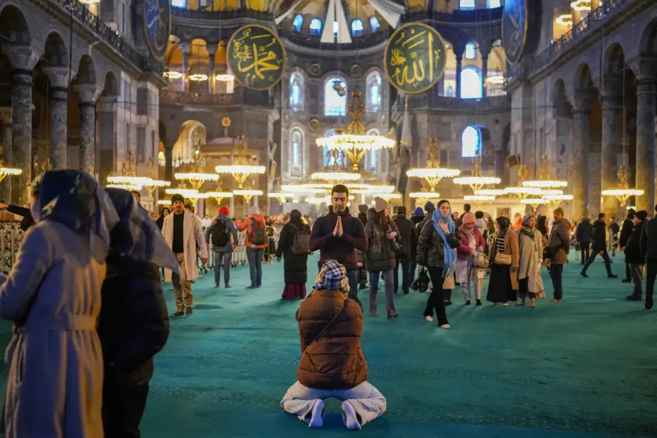 Menschen beten und besichtigen die Hagia Sophia. Der Eintritt ist frei, aber die Atmosphäre ist ehrfürchtig.