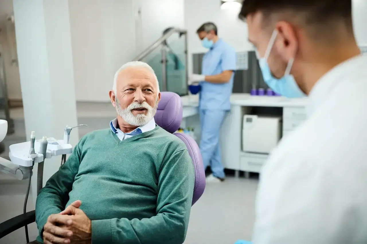 pacjent rozmawia z dentystą uśmiechnięci