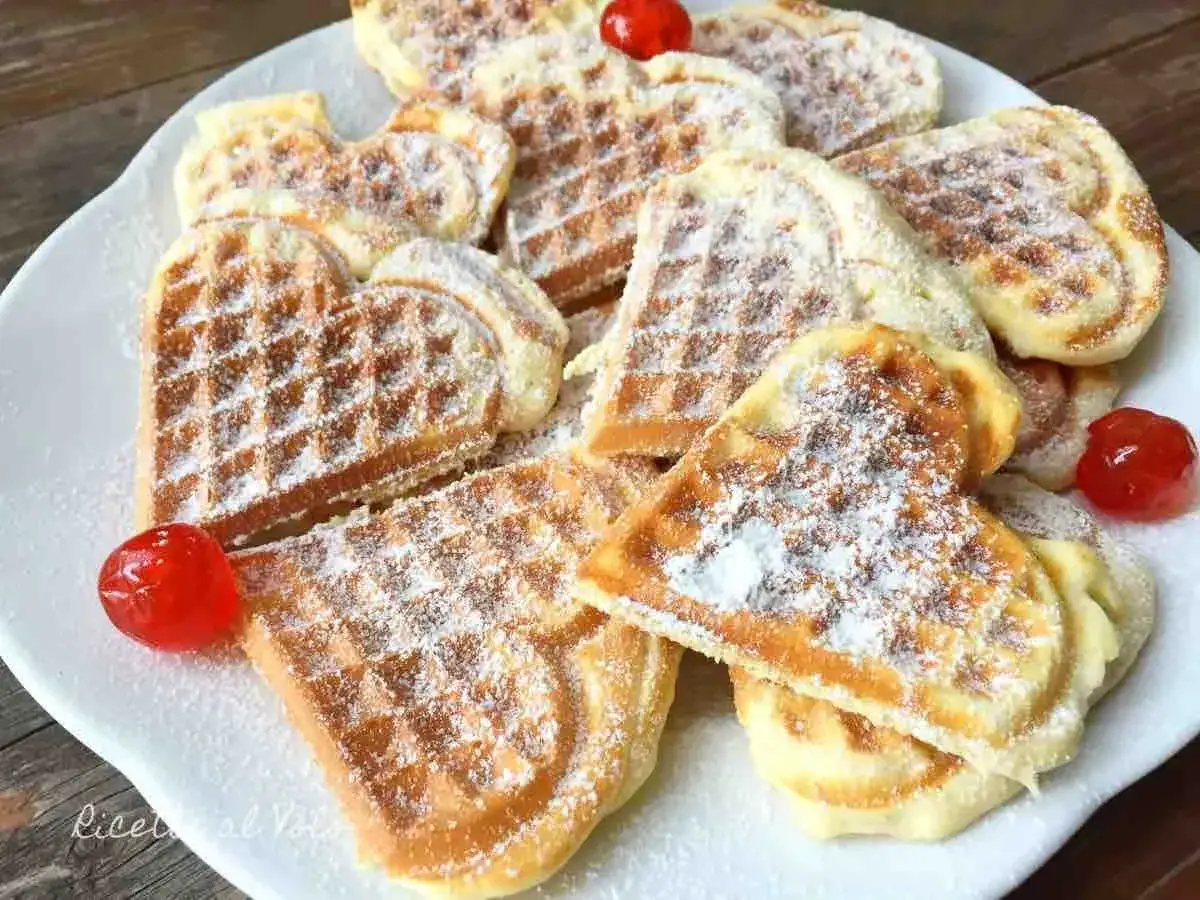 Cuori di waffle dorati, spolverati di zucchero a velo e decorati con ciliegie candite. Ecco come fare i waffle perfetti per San Valentino!