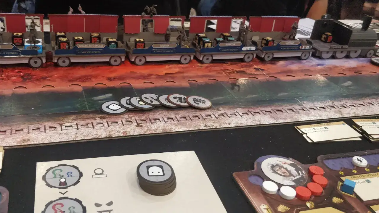 Miniaturowy pociąg Orient Express, groza w wagonach, figurki pasażerów i tajemnicze żetony na planszy.