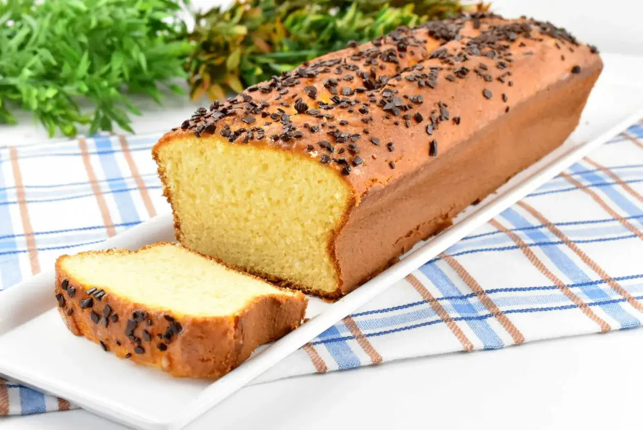 Puszysta babka z adwokatem, posypana czekoladową posypką, prezentuje się apetycznie na białej tacy.