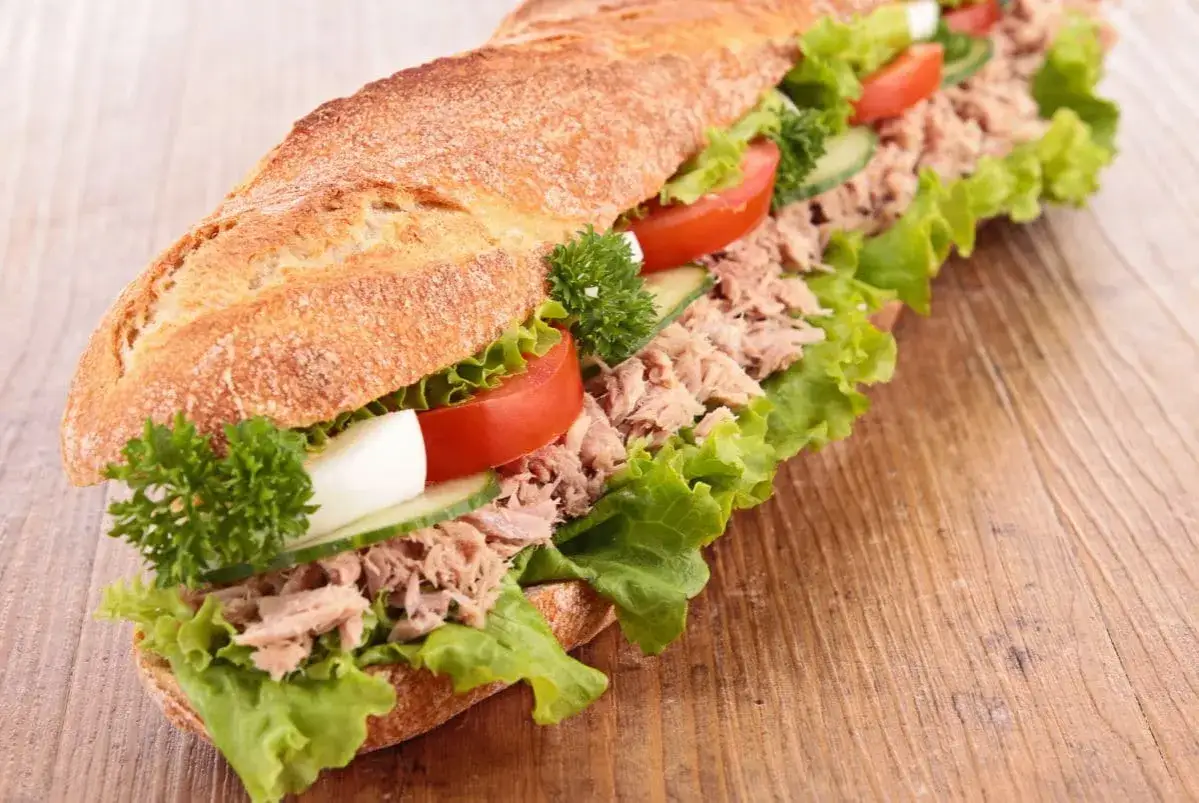 Langes Baguette mit Thunfisch-Dip, Salat, Tomaten, Gurken und Ei.
