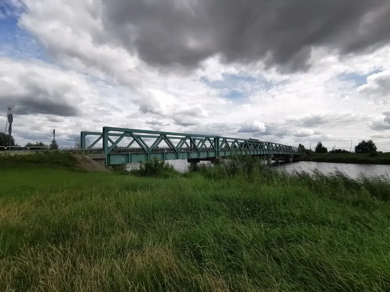 Zielony most nad rzeką, idealny na przejażdżkę po trasach rowerowych Elbląg.