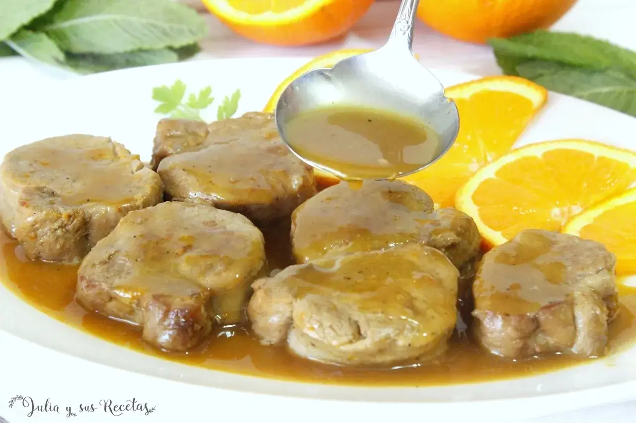 Filetes de solomillo a la naranja, ba&ntilde;ados en su jugosa salsa, acompa&ntilde;ados de rodajas de naranja y hojas verdes.