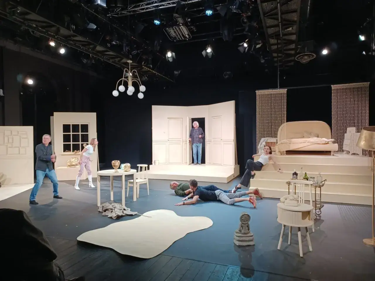 Scena teatralna z ludźmi w dziwnych pozach. Czy to farsa? Co to za sytuacja?