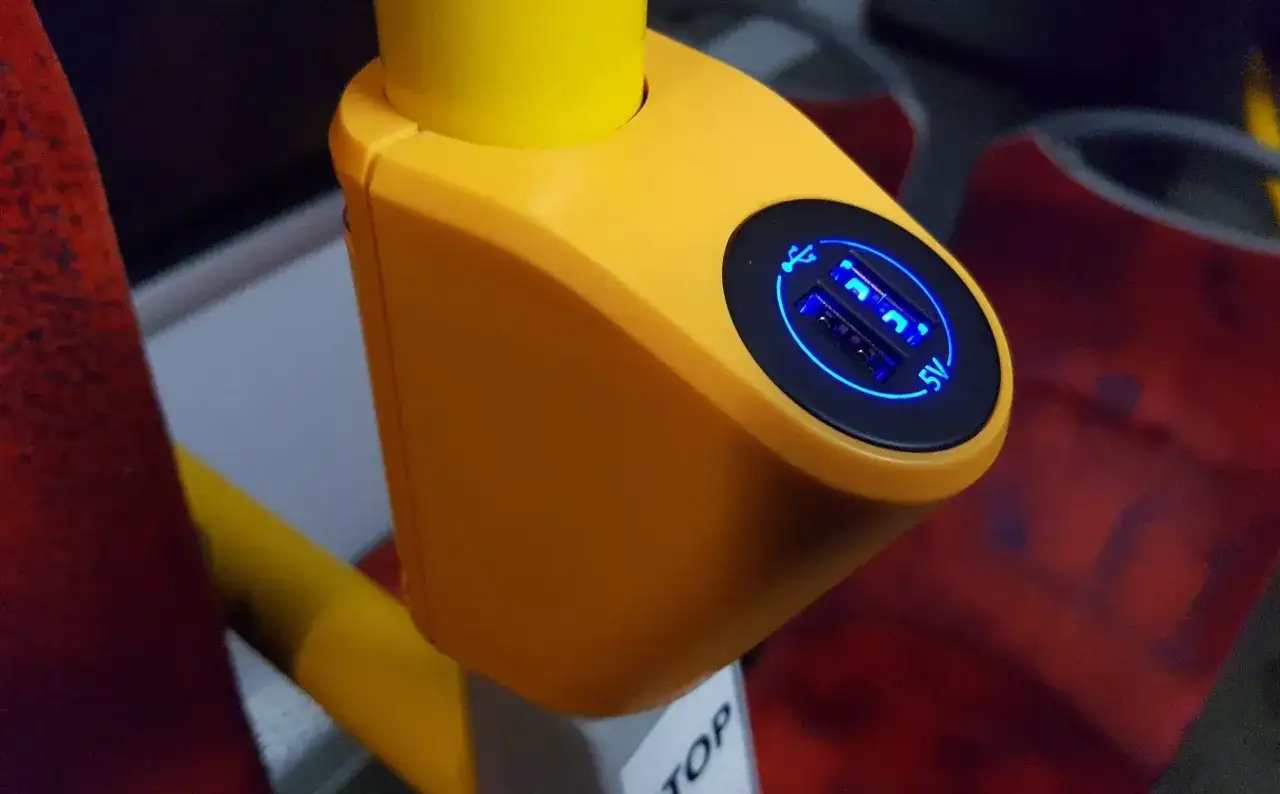 Jasne, oto opis:

Żółta obudowa z dwoma podświetlanymi na niebiesko gniazdami USB 5V, idealna do ładowania urządzeń podczas podróży Flixbusem.