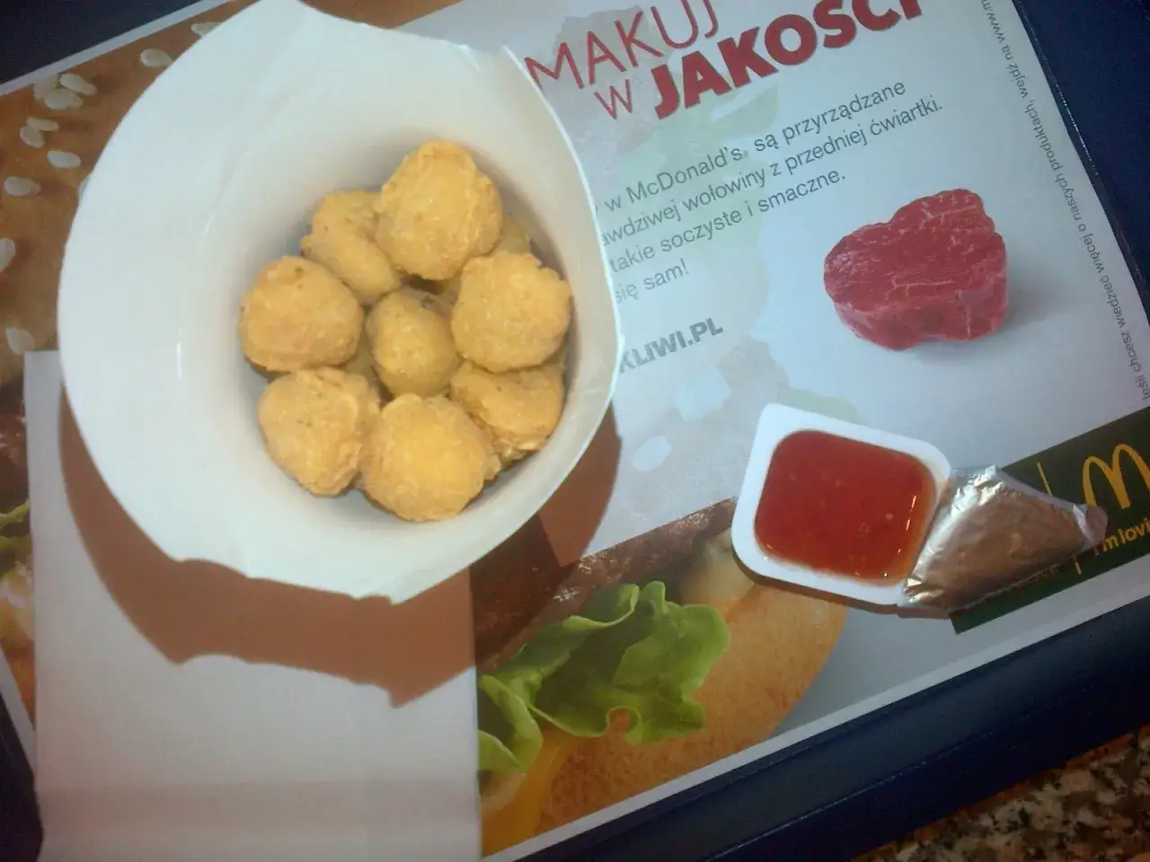 Pudełko pełne chrupiących 20 McNuggets czeka na zanurzenie w sosie. Idealna przekąska na szybki głód.