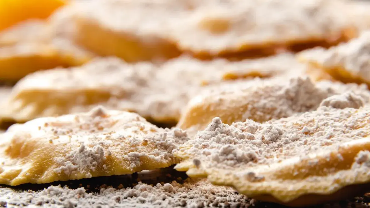 Tortelli del Mugello appena sfornati, cosparsi di zucchero a velo, invitano a un assaggio di tradizione.