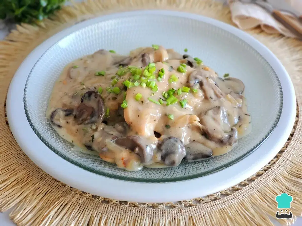 Pollo con champi&ntilde;ones en cremosa salsa de vino blanco, adornado con cebollino fresco. Un plato delicioso y reconfortante.