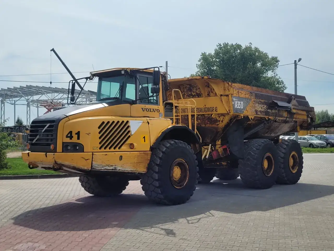Żółty wozidło budowlane Volvo A35D z numerem 41 gotowe do pracy na placu budowy.