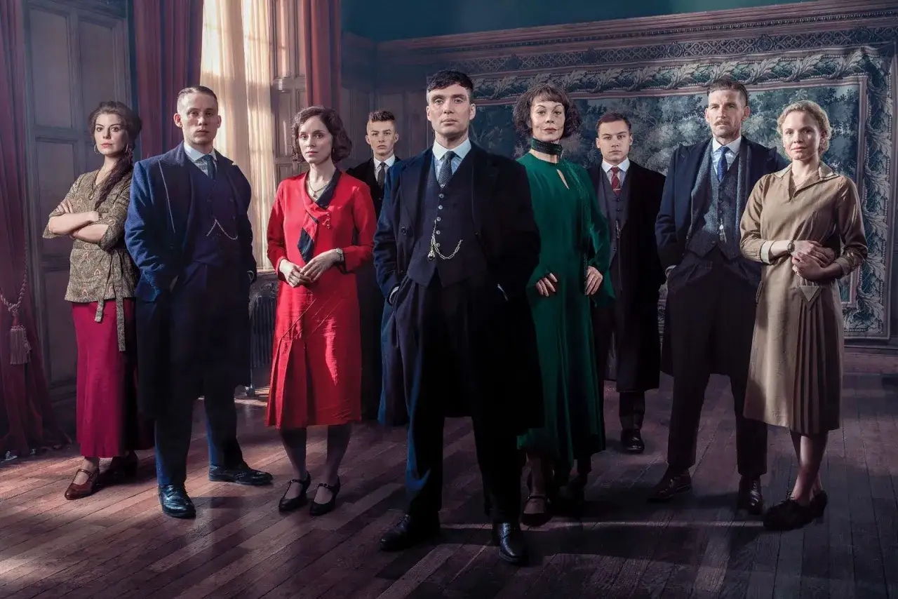 Die Shelby-Familie versammelt sich für die **Peaky Blinders neue Staffel**. Tommy im Anzug führt die Gruppe an, umgeben von seinen Lieben.