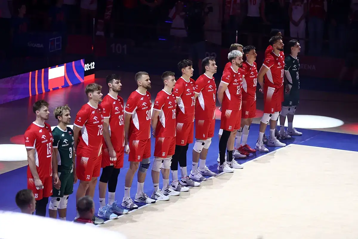 Drużyna siatkarzy w biało-czerwonych strojach stoi w rzędzie, gotowa do walki w lidze światowej w piłce siatkowej.