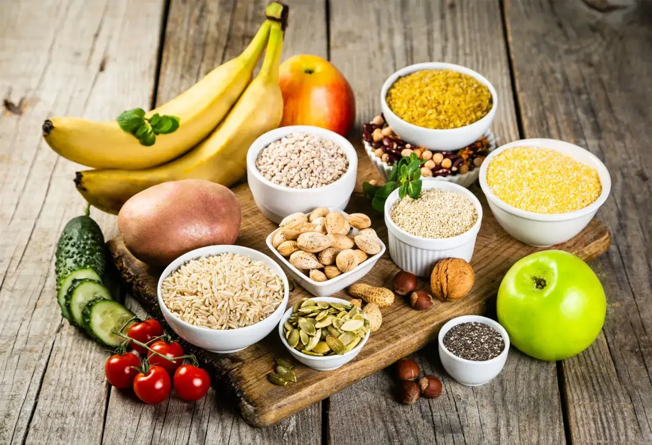Bananen, Äpfel, Kartoffeln, Reis, Nüsse, Samen und Hülsenfrüchte – eine Vielfalt an ballaststoffe produkten für eine gesunde Ernährung.