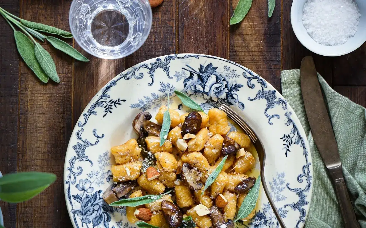 Gnocchi de potimarron aux champignons et amandes, une recette automnale savoureuse.