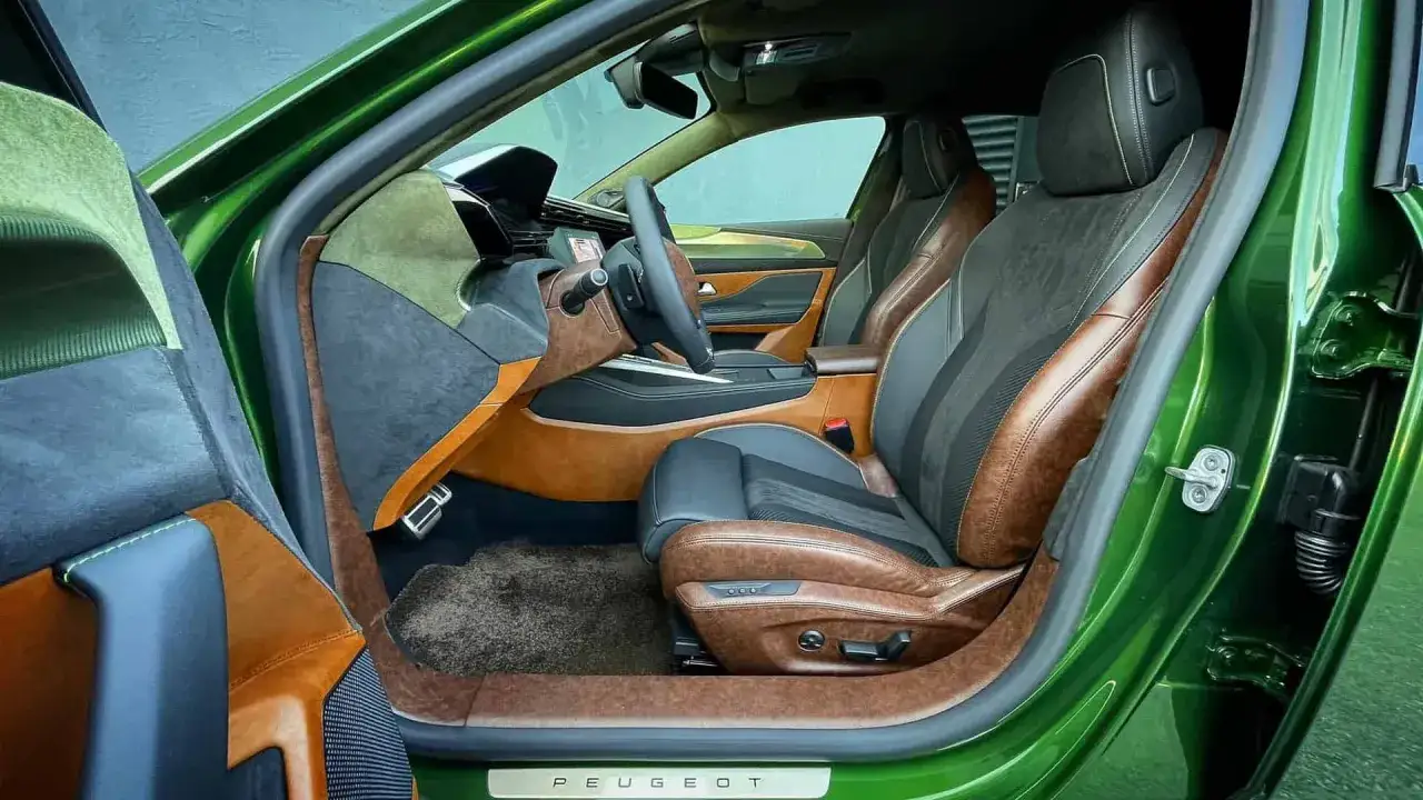 Wnętrze Peugeota 308 T9 w zielonym kolorze, z brązowo-czarnymi skórzanymi fotelami i detalami z alcantary.