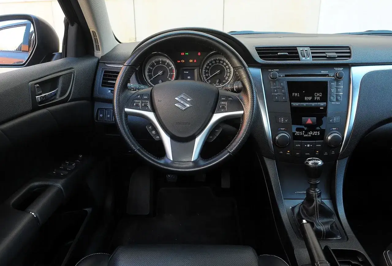Wnętrze Suzuki Kizashi: kierownica ze sterowaniem, deska rozdzielcza z radiem i nawiewami, dźwignia zmiany biegów.