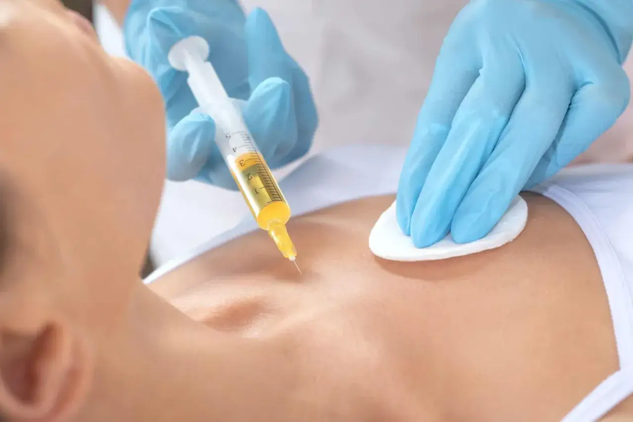En injektion med intim fillers ges av en person med bl&aring; handskar.