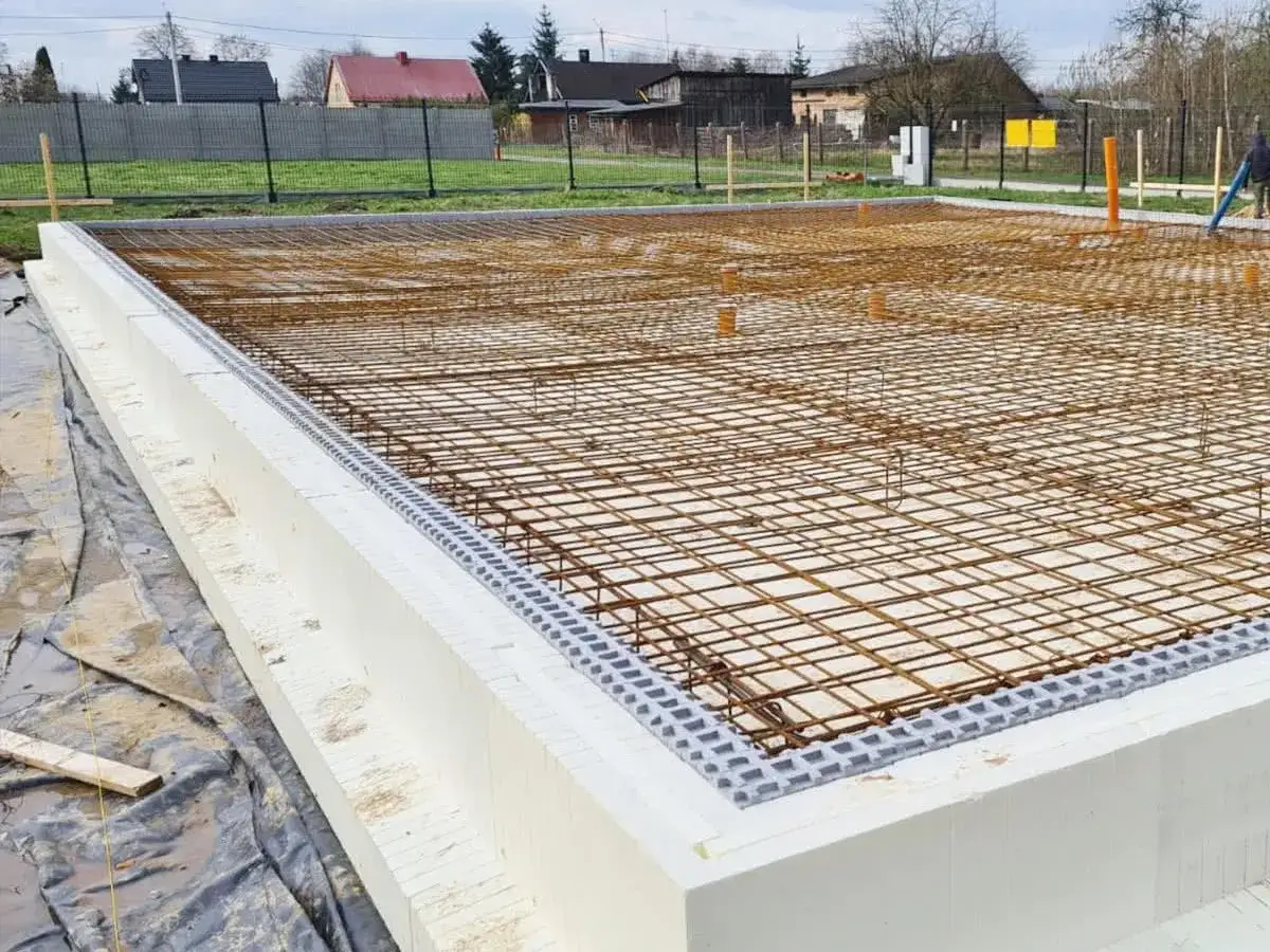 Siatka zbrojenia czeka na beton. Fundament z polistyrenu ekstrudowanego tworzy solidną bazę.