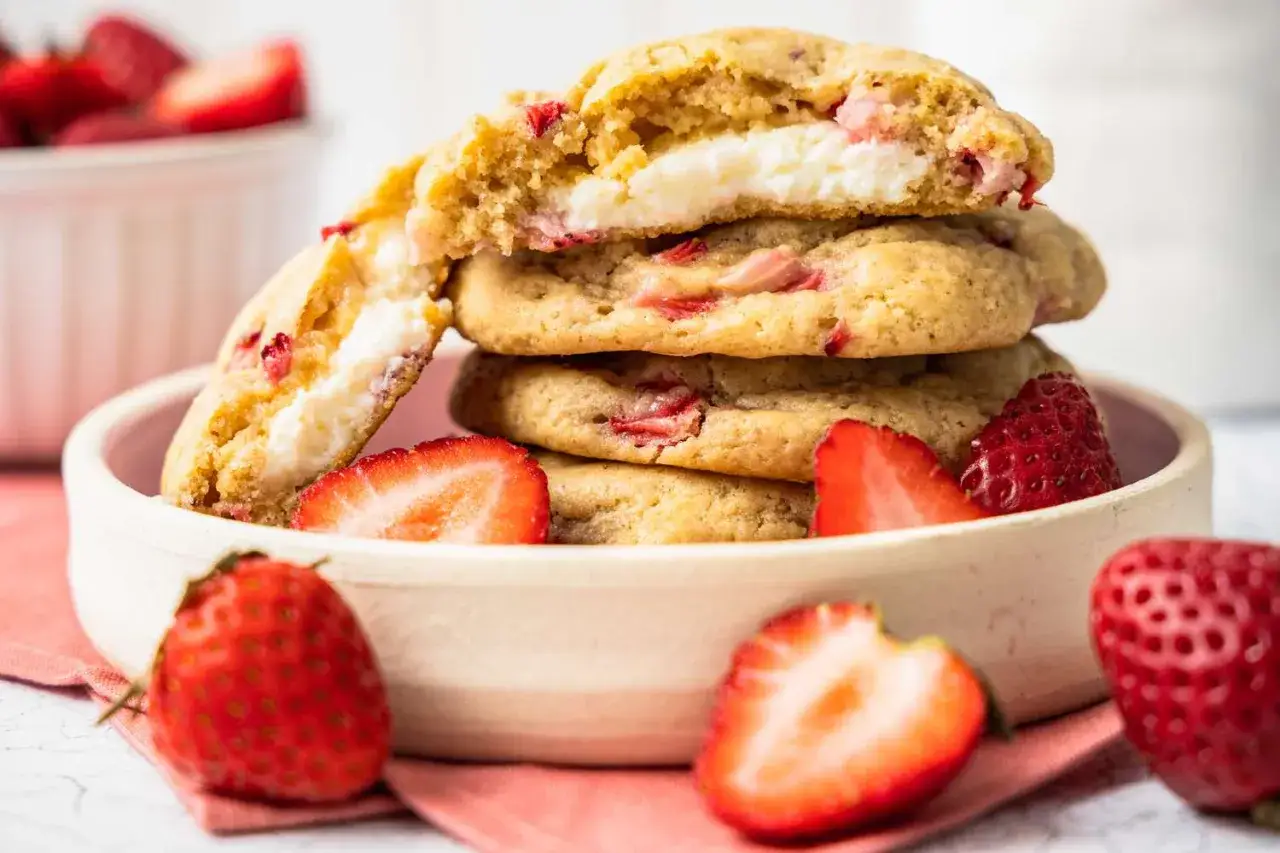 Gestapelte Cheesecake-Cookies mit Erdbeeren, gefüllt mit cremiger Frischkäsefüllung und Fruchtstücken.