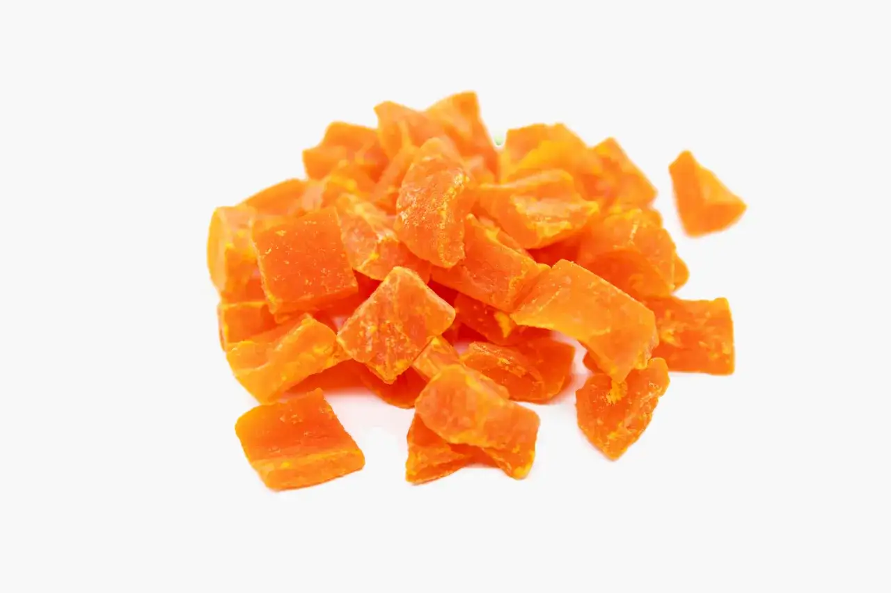 Piccolo mucchio di papaya disidratata a cubetti, arancione brillante, con le sue propriet&agrave; benefiche.