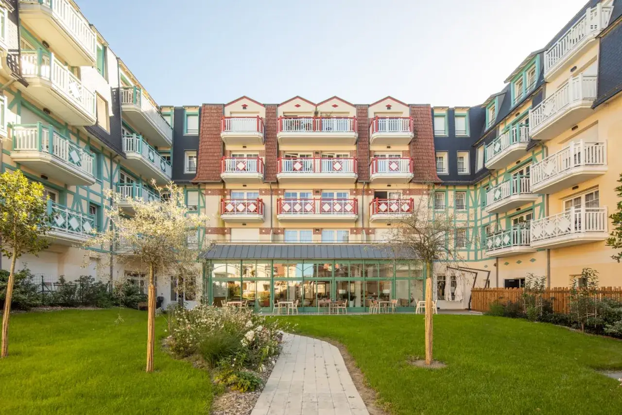 Un établissement de retraite avec une cour verdoyante et une architecture colorée. Un endroit où l'on se demande : cap retraite c'est quoi ?