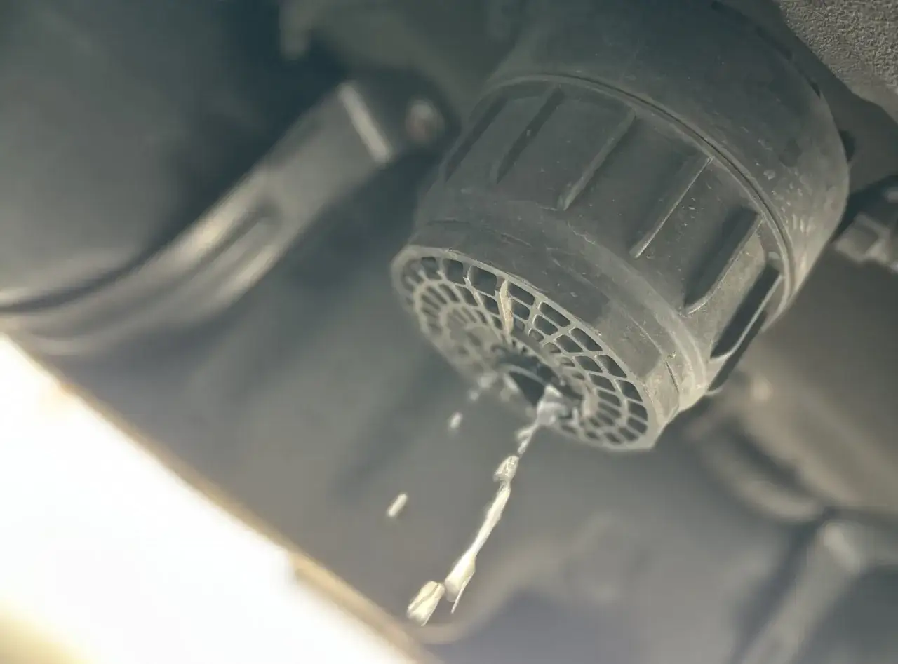 Fuite d'huile diesel dans un moteur essence. Le filtre &agrave; carburant fuit, une goutte de liquide s'&eacute;chappe.