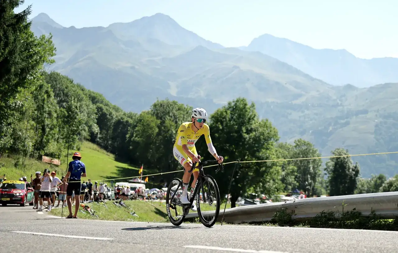 Een wielrenner in de gele trui rijdt door de bergen. Dit is een etappe van de Tour de France, die ongeveer drie weken duurt.