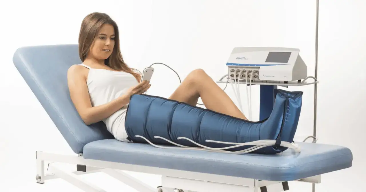 Donna sdraiata su lettino con gambe in manicotto per pressomassaggio cos'&egrave;. Dispositivo medico per drenaggio linfatico.