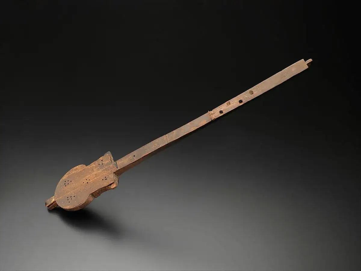 Drewniany instrument z otworami, przypominający flet lub lirę. Jedne z pierwszych instrumentów muzycznych, świadectwo dawnych melodii.