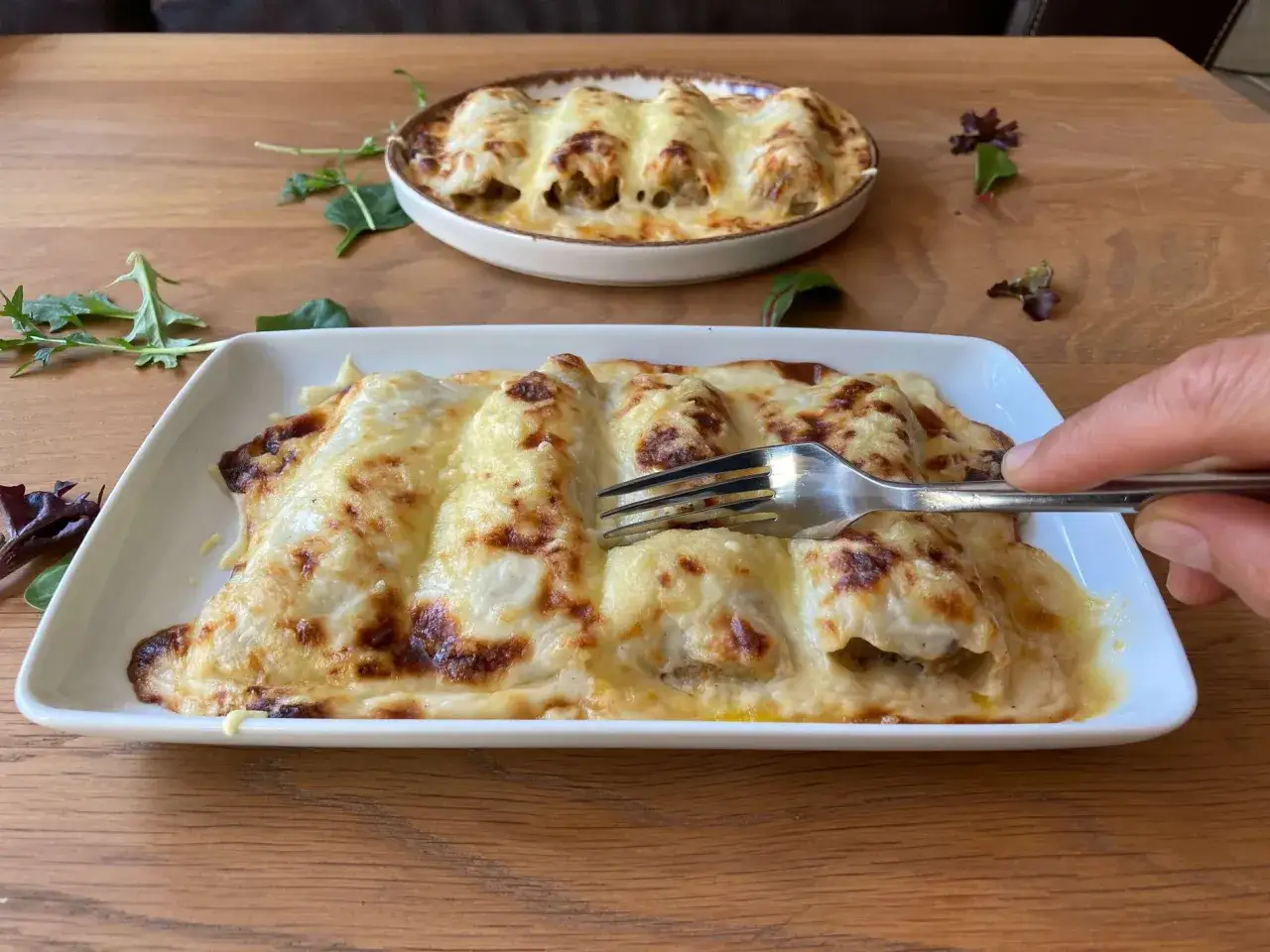 Canelones de carne picada gratinados con queso, listos para disfrutar. Un plato casero que invita a servirse.