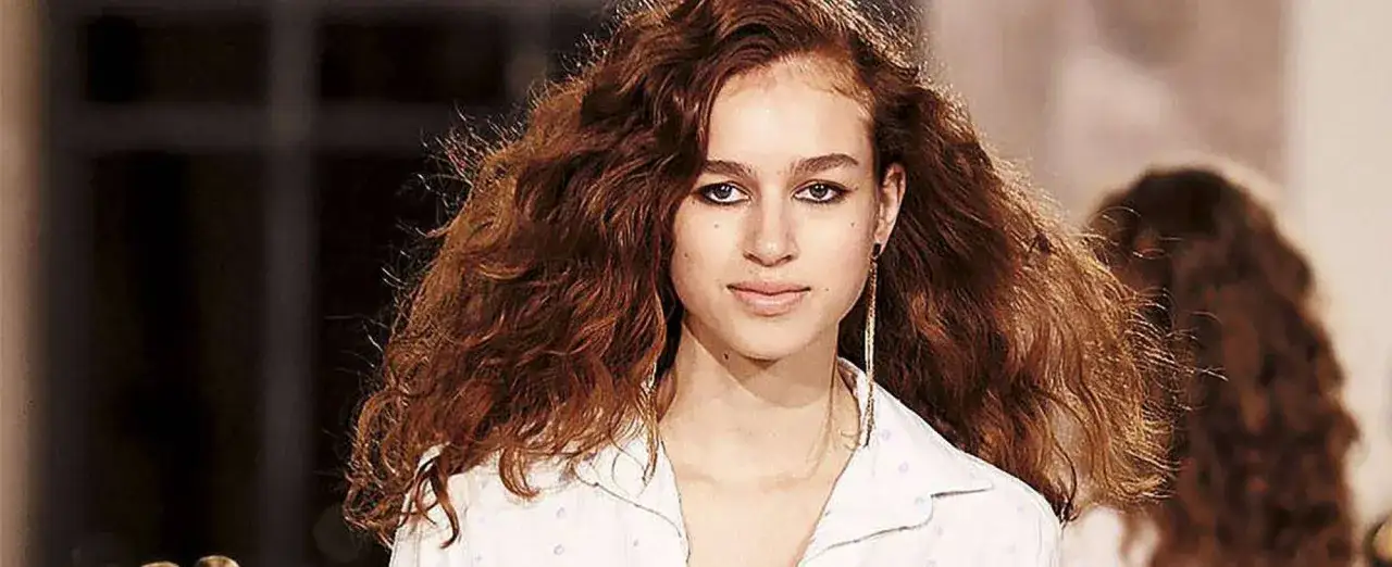 Joven con cabello rizado color cobre, como un atardecer de cowboy.