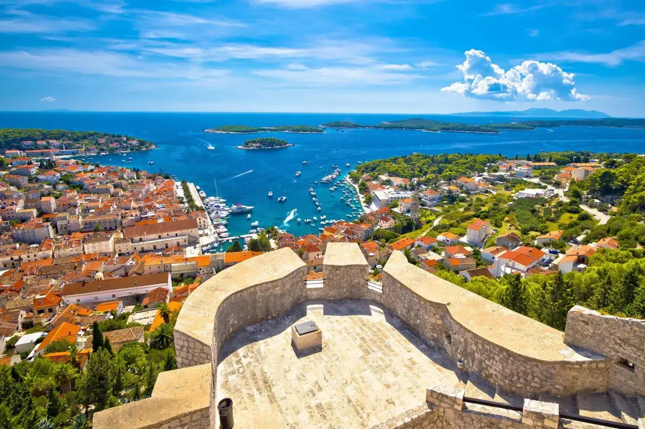 Widok na Hvar, uznawany za najładniejszą wyspę Chorwacji, z kamiennej twierdzy. Błękitne morze, białe żaglówki i urokliwe miasteczko.