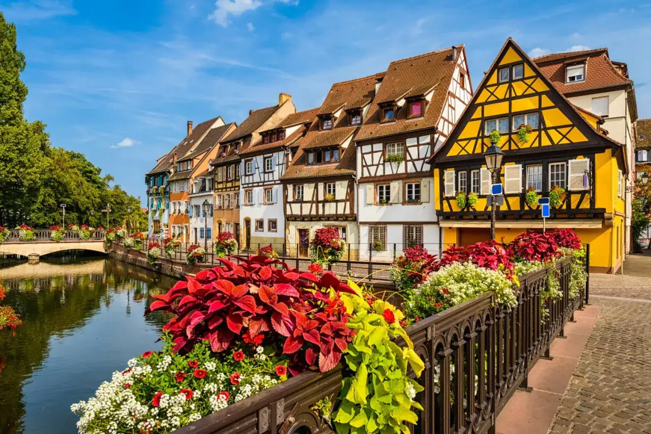 Maisonnettes color&eacute;es et fleuries le long d'un canal, parfait pour visiter Colmar en 1 jour.