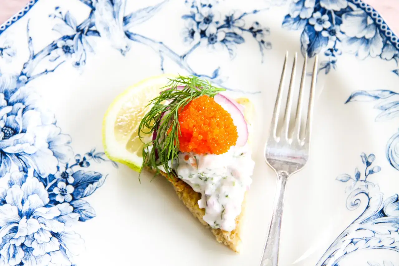 En läcker vegetarisk toast Skagen med dill, rödlök och orange rom på en vacker blåvit tallrik. En gaffel ligger bredvid.