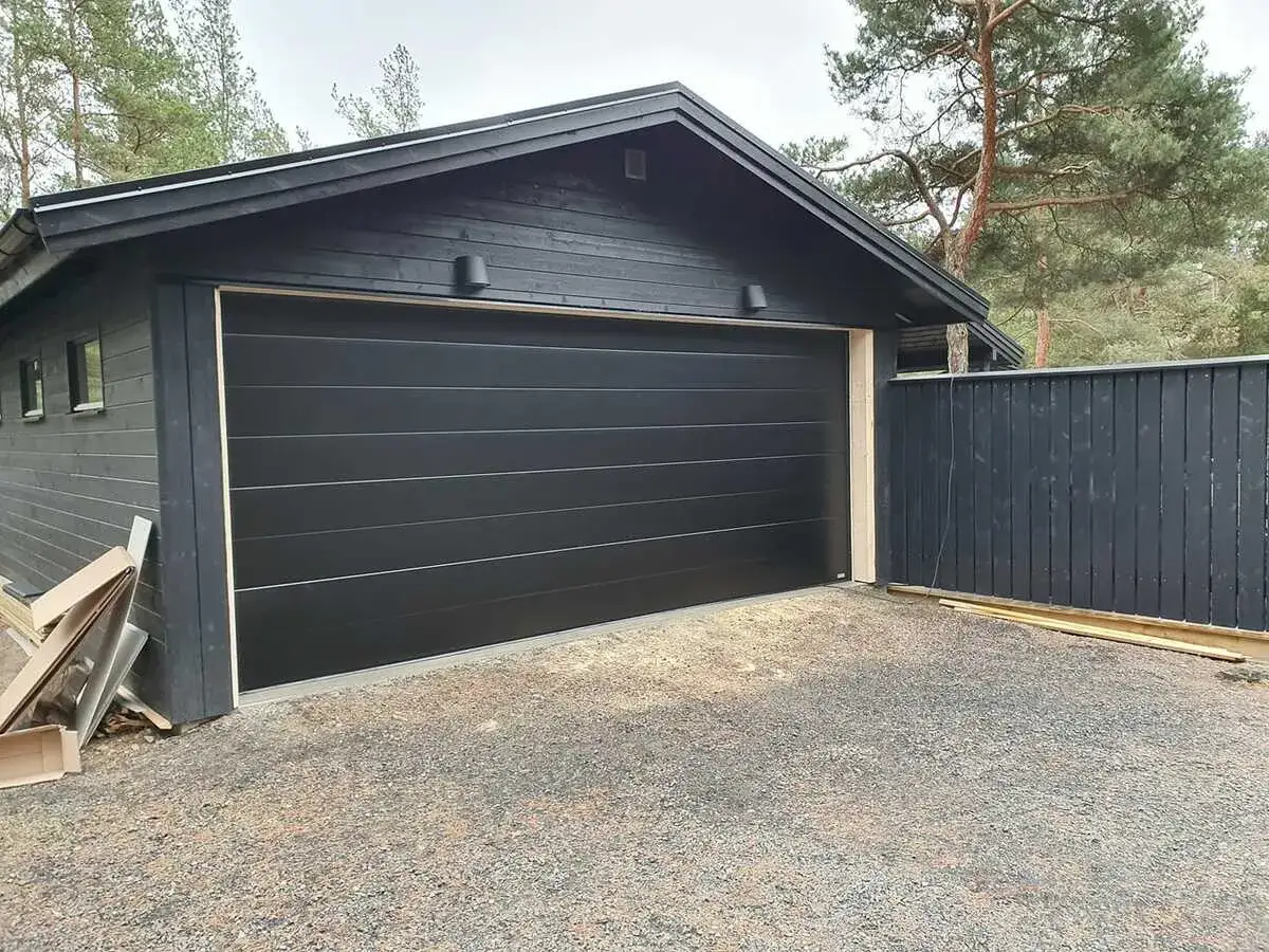 Nyinstallerad svart garageport montering på ett modernt garage.