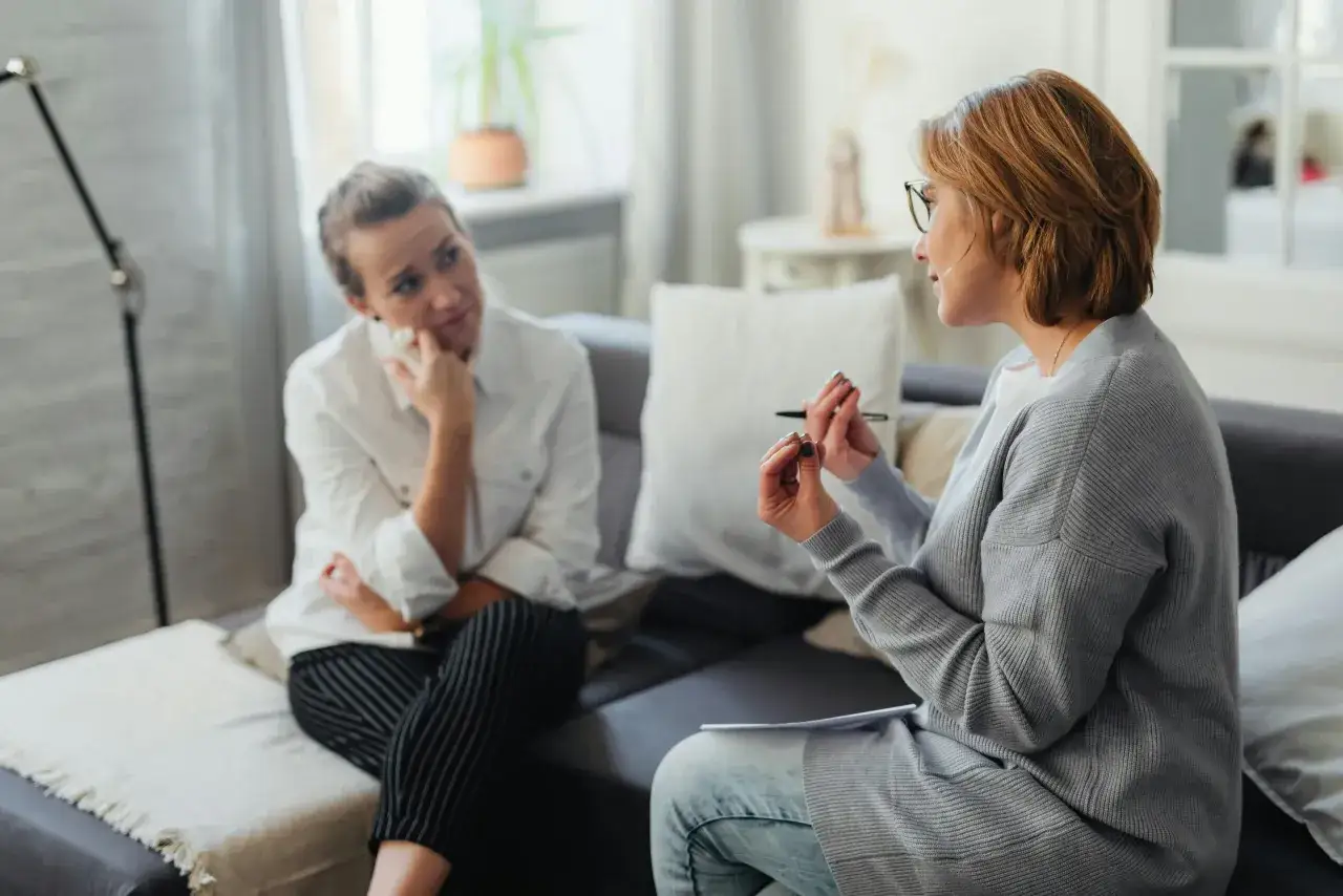 Una donna con espressione pensierosa ascolta una terapeuta. Forse la psicoterapia non funziona per lei, ma continua a cercare risposte.