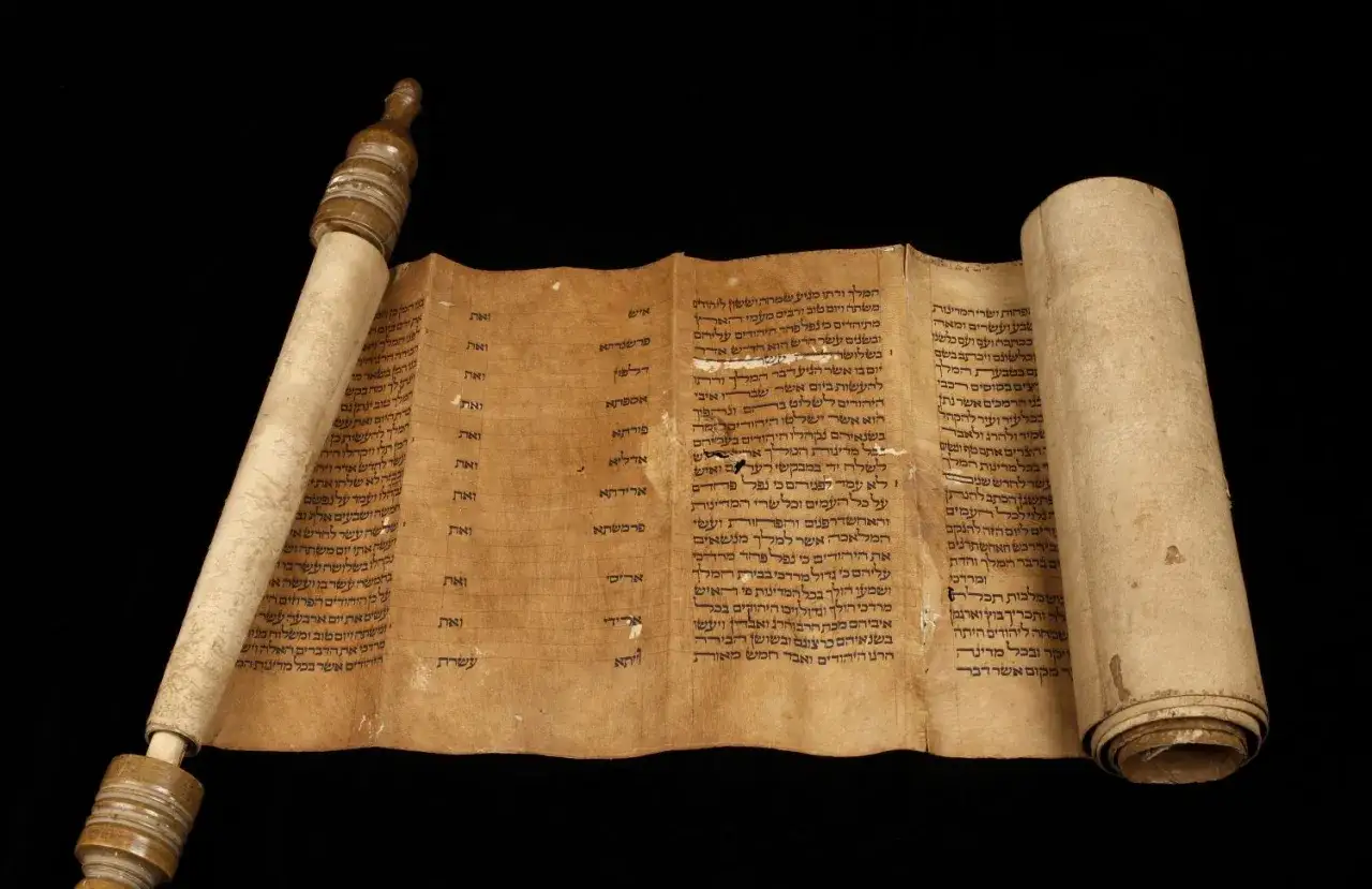 Alte Schriftrolle mit hebr&auml;ischen Texten, die an einen h&ouml;lzernen Stab gerollt ist. Der Text k&ouml;nnte aus Psalm 135 stammen.