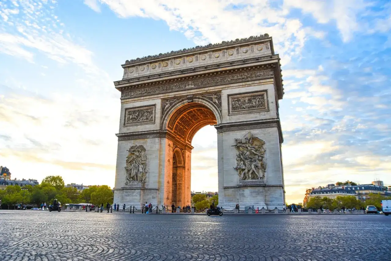 Triumfbågen, en av de mest kända byggnaderna i Paris, reser sig majestätiskt mot en molnig himmel.