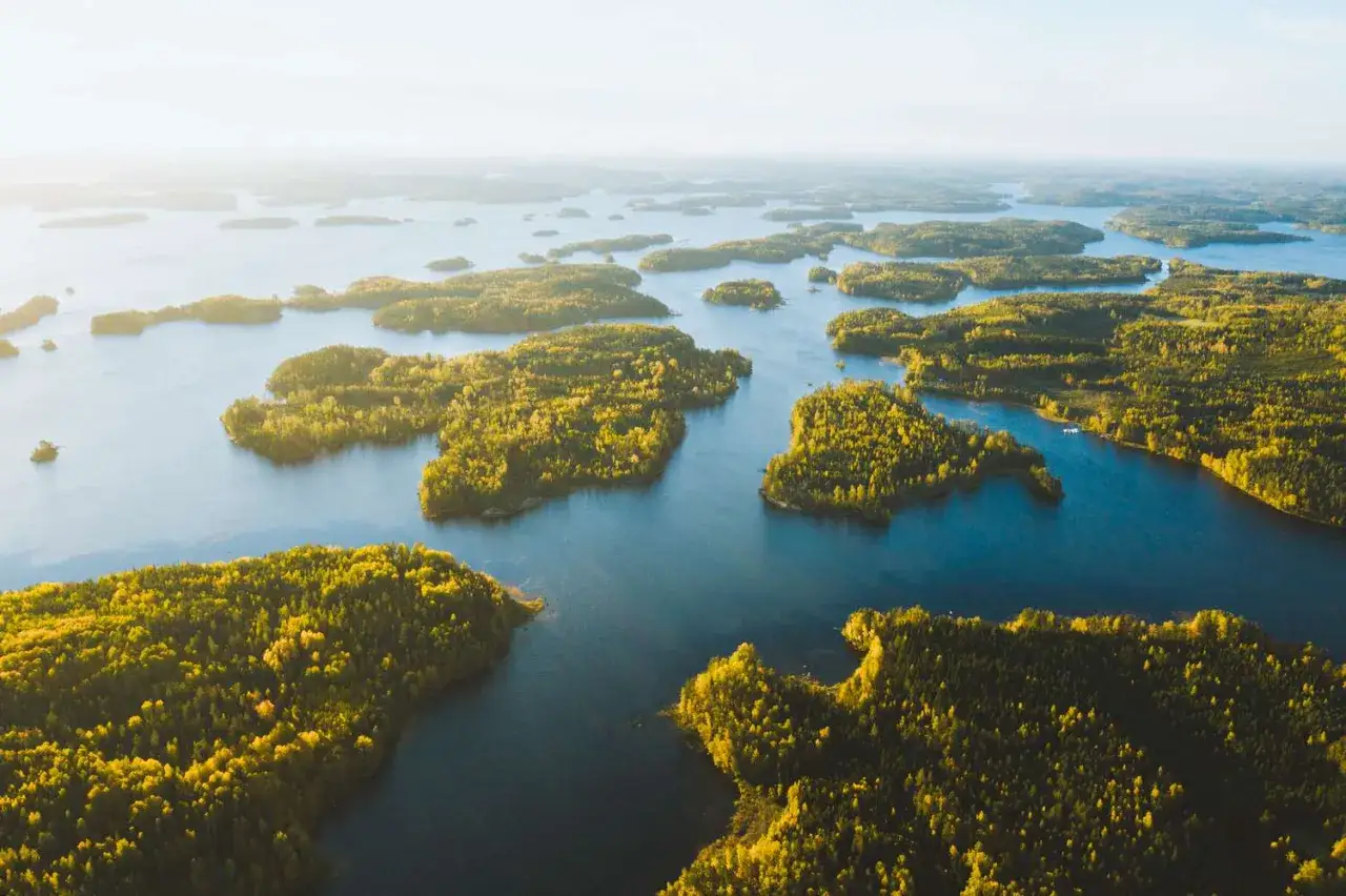 Paysage de milliers d'îles boisées et de lacs bleus. Idéal pour savoir que faire en Finlande : explorer, naviguer, se ressourcer.