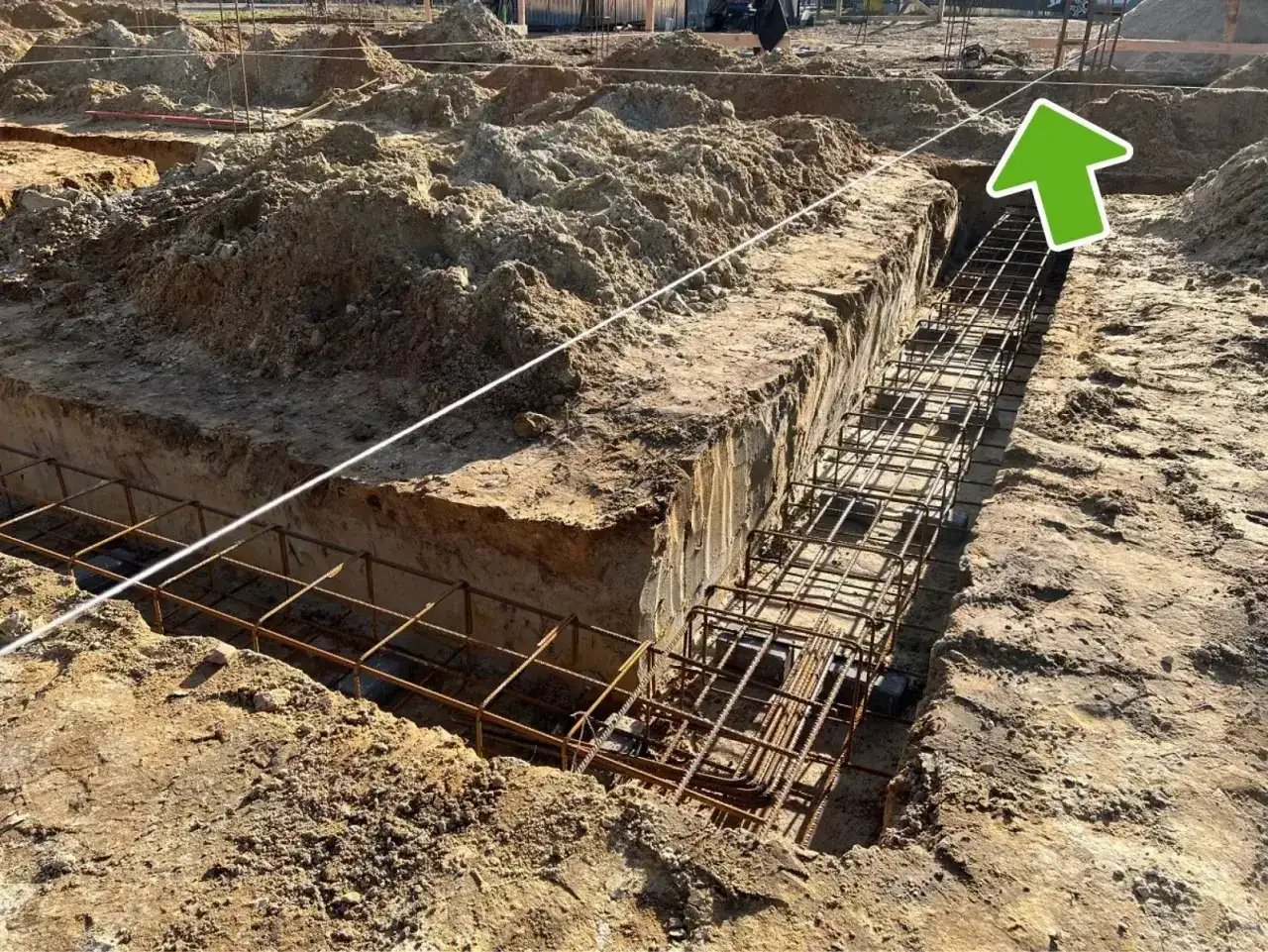 Wytyczenie budynku: zbrojenie ławy fundamentowej w wykopie. Widać sznur geodezyjny do precyzyjnego wyznaczenia.