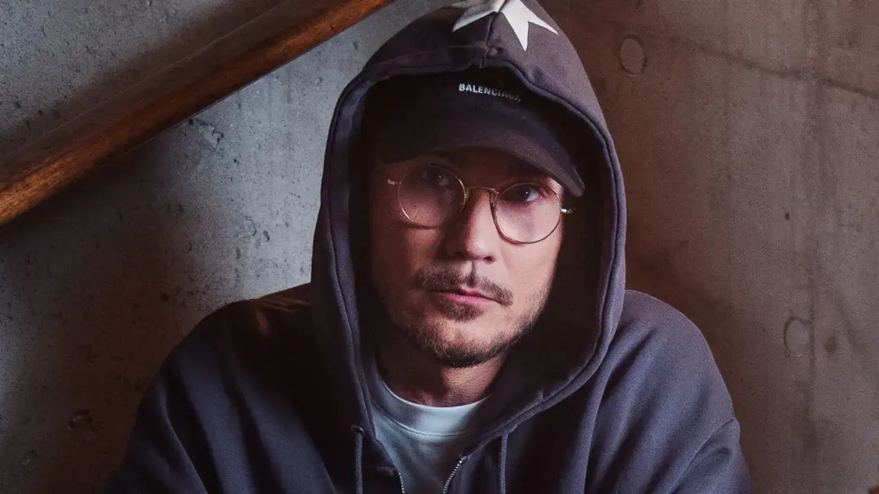 Pezet w okularach i bluzie z kapturem, z gwiazdą na kapturze, wygląda jakby właśnie dowiedział się, że pezet został ojcem.